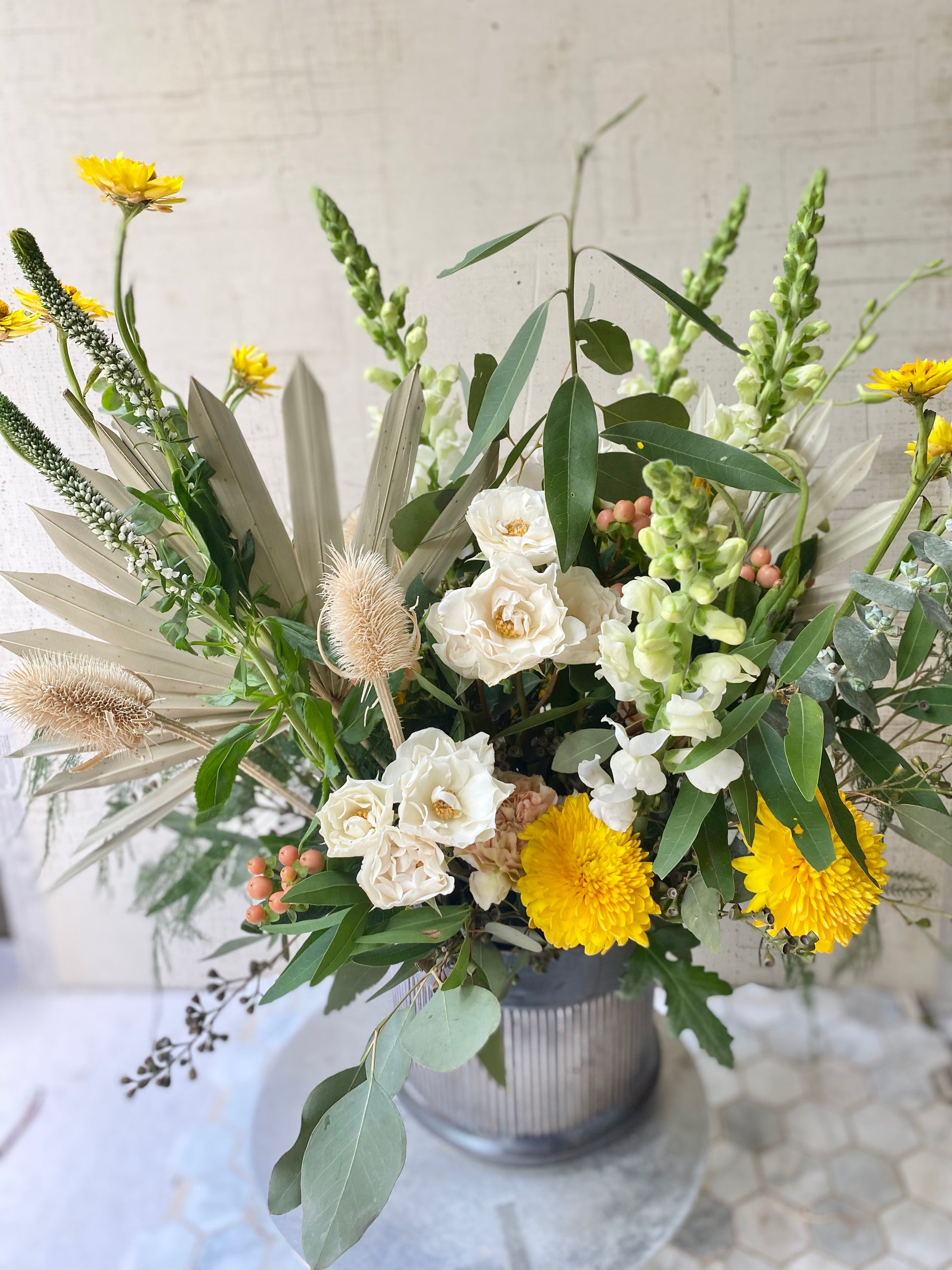 Top view of Large version of The Rambler, a textured dried flowers in Bohemian style floral arrangement with Soft Orange, yellow, cream flowers with loose sage foliage 